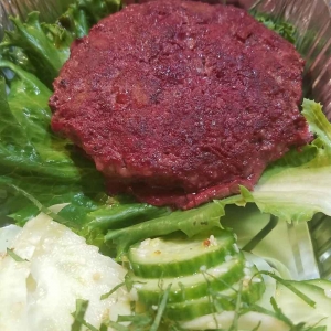 Beet and beef burger on lettuce buns with cucumber salad