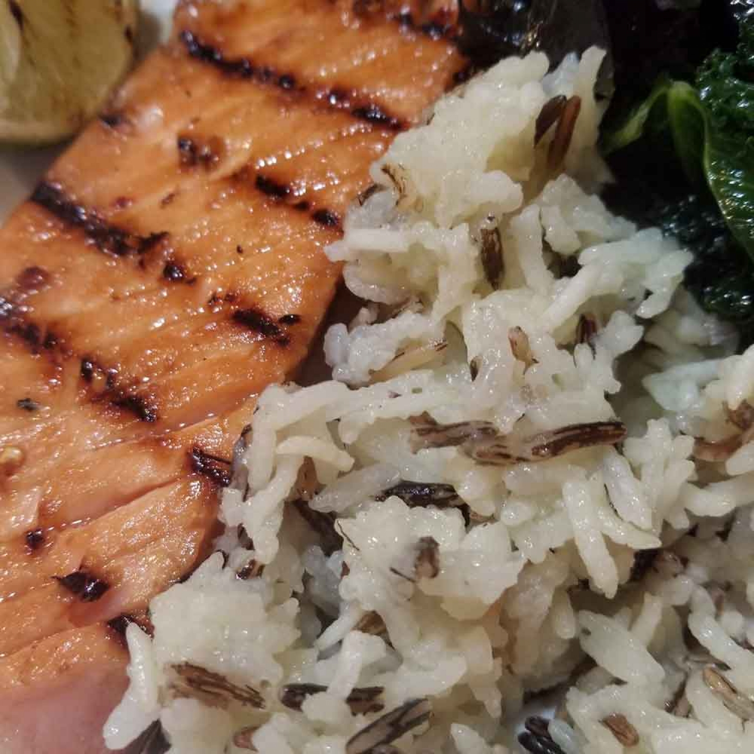 Grilled salmon with wild rice and sautéed kale